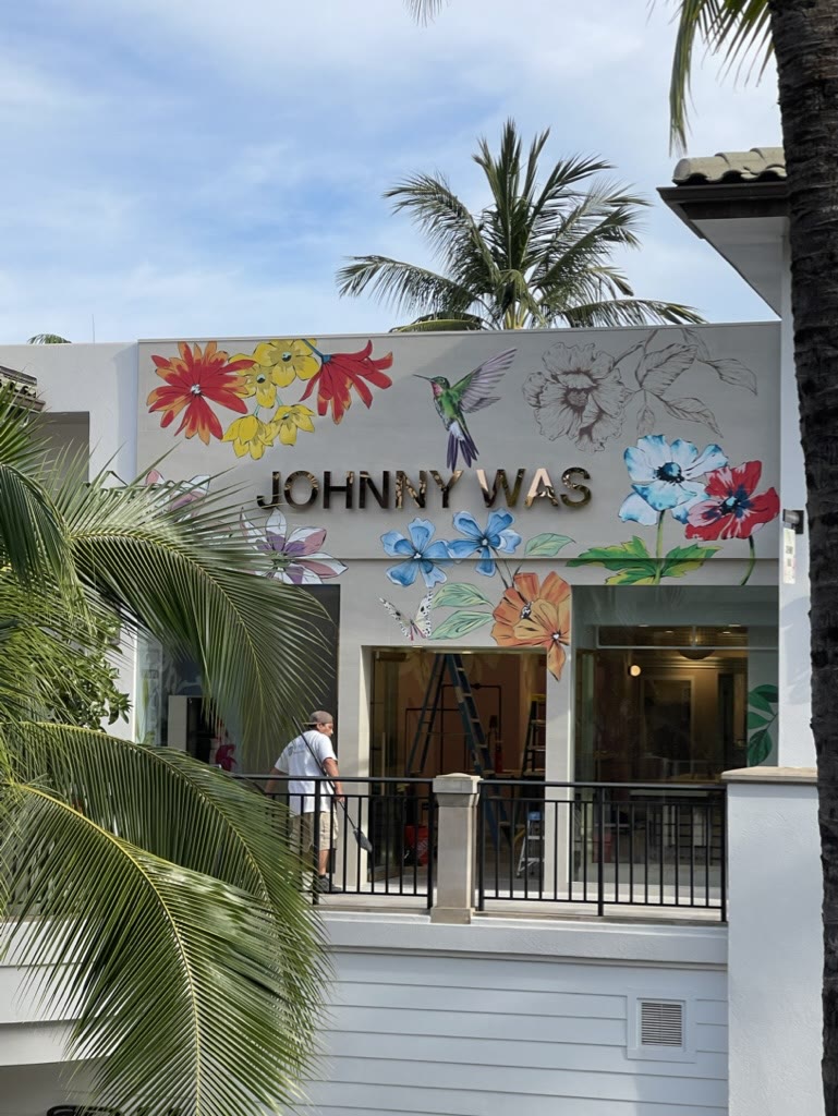 A boutique storefront with a painted floral mural above the entry